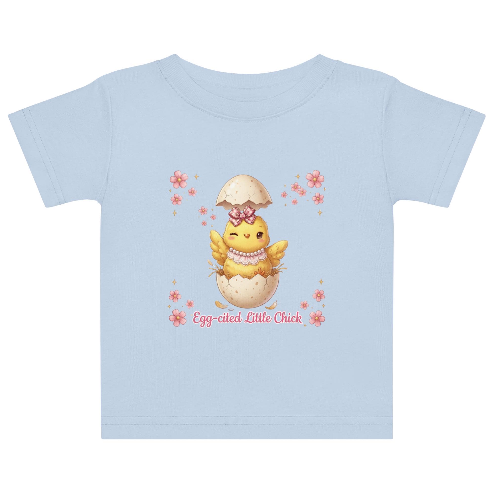 May include: White short-sleeved t-shirt featuring a cartoon chick hatching from an egg, with the text "Egg-cited Little Chick" in pink. The chick is yellow with a pink bow and necklace. The child is wearing a pink bow.